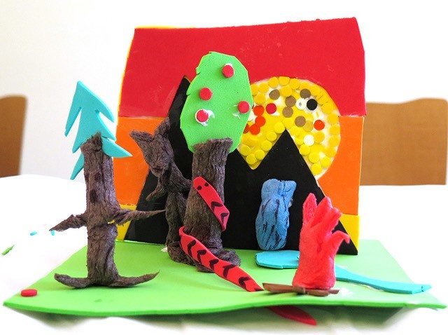 Colorful construction of different materials showing a landscape and trees made by a child.