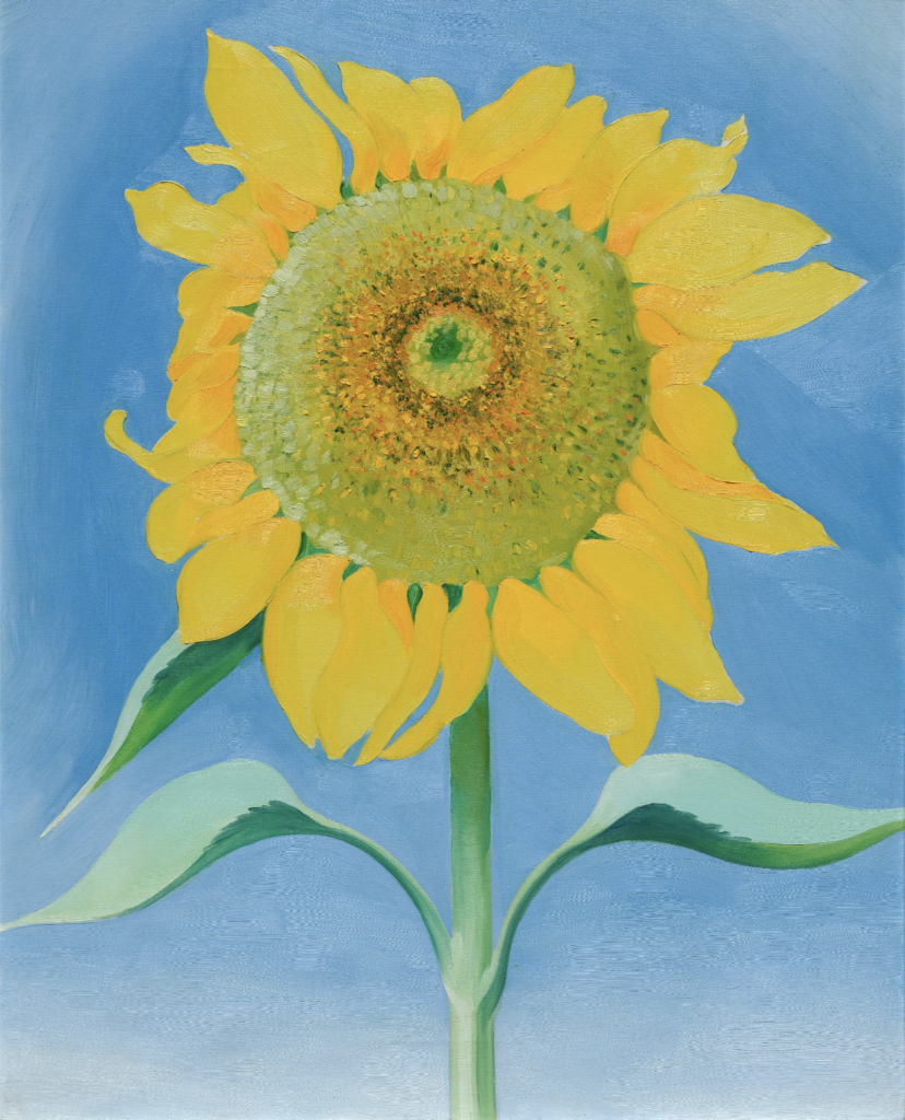 A close-up, enlarged depiction of a large sunflower with yellow petals, a yellow, gold, and green center, and a long green stem and leaves. The large sunflower takes up the entire canvas and is painted against a light blue background.