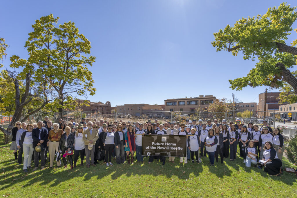 Group of people holding banner in front of construction site