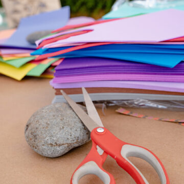 Close-up photo of art supplies including foam, scissors and a rock